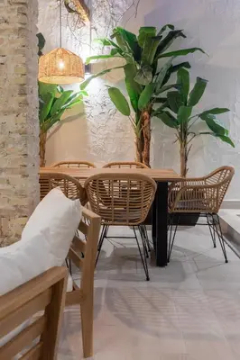 a dining room with a table and chairs and plants at Apartamento con piscina y terraza in Valencia