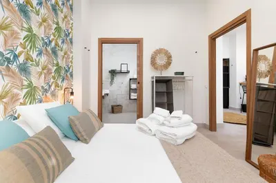 a living room with a white couch and a mirror at Apartamento con piscina y terraza in Valencia