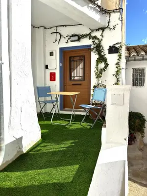 a patio with green grass and a table and chairs at La Casucha de Chulilla in Chulilla