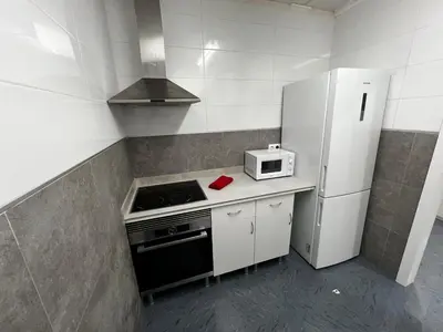 a small kitchen with a stove and a refrigerator at RMN TOURIST HOME in Valencia