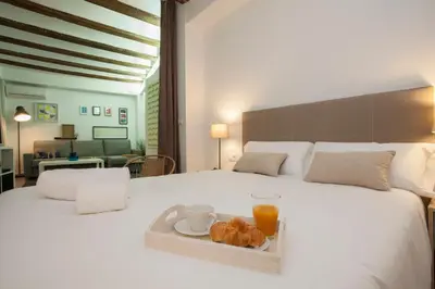 a white bed with a tray of food on it at SingularStays Mercado Central in Valencia