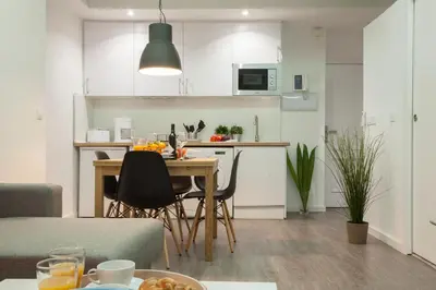 a kitchen and living room with a table and chairs at SingularStays Mercado Central in Valencia
