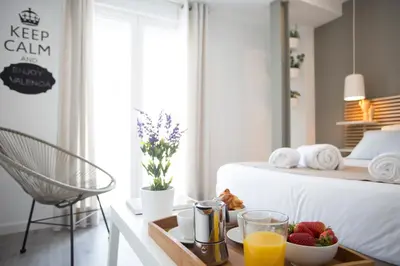 a bed with a tray of fruit on a table at SingularStays Mercado Central in Valencia