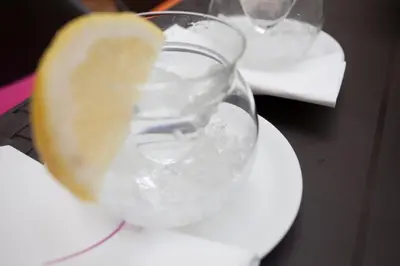 a glass of water with a lemon on a table at SingularStays Mercado Central in Valencia