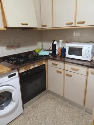 a kitchen with a microwave and a washing machine at Apartamento tradicional in Canet de Berenguer