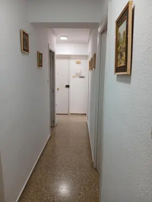 a hallway with white walls and a white door at Apartamento tradicional in Canet de Berenguer