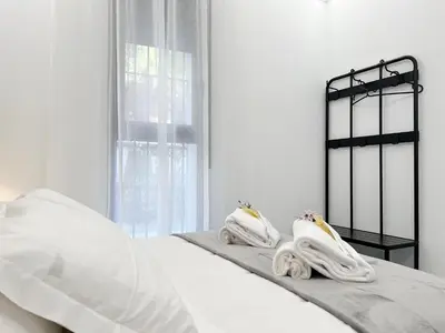 a white bedroom with white sheets and towels on a bed at Apartamento en la Gran Manzana in Valencia