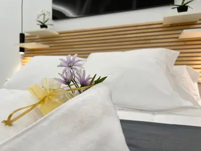 a bouquet of flowers on a bed with white pillows at Apartamento en la Gran Manzana in Valencia