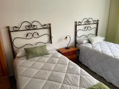 a bedroom with two beds and a lamp on a night stand at Apartamento Diagonal in Nules