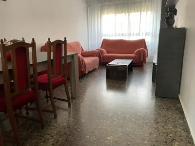 a living room with a couch and a table and chairs at Apartamento Diagonal in Nules