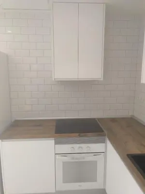 a kitchen with a stove and a white cabinet at Apartamento moderno de 70 metros a 300 metros de la playa in Valencia