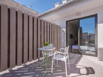 a patio with a table and chairs on a balcony at Livensa Living Studios Valencia Viveros Hotel - Apartamento in Valencia