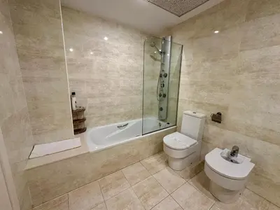 a bathroom with a shower and a toilet and a tub at Reinapart Patacona Beach 40 in Valencia