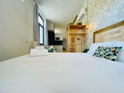 a bedroom with a large bed and a living room at FLORIT FLATS - The Cabanyal & Port Suites in Valencia
