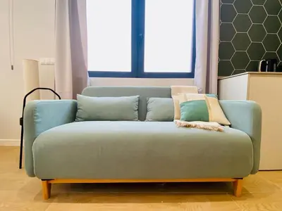 a blue couch with pillows on it in a living room at FLORIT FLATS - The Cabanyal & Port Suites in Valencia