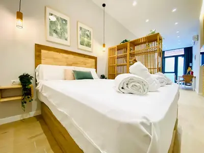a large white bed with towels on it in a bedroom at FLORIT FLATS - The Cabanyal & Port Suites in Valencia
