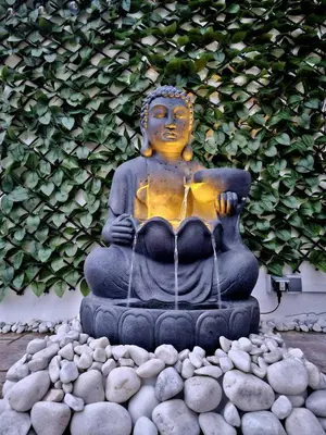 a statue sitting on a pile of rocks at Buen Estar, piscina, barbacoa, jacuzzi en Valencia in Turís