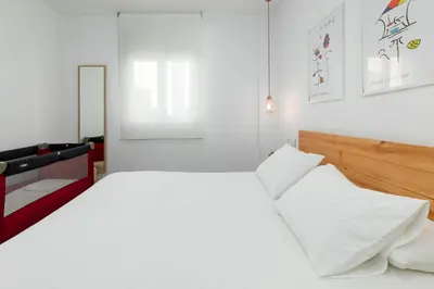 a bedroom with a large bed with white sheets at ApartUP Valencia Opera in Valencia