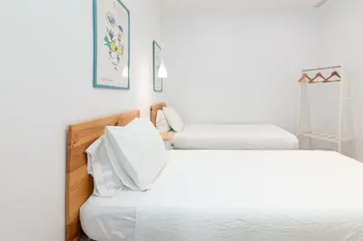 two beds in a room with white walls at ApartUP Valencia Opera in Valencia