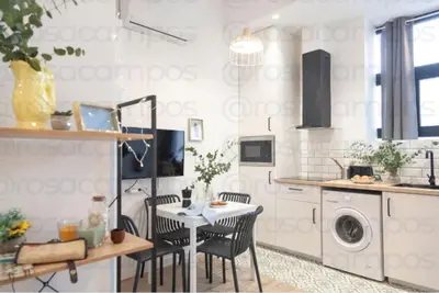 a white kitchen with a table and chairs at AL5 Seaside Bliss-stylish loft steps from Malvarrosa in Valencia