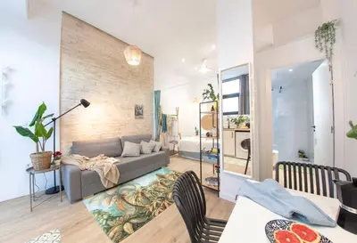 a living room with a couch and a table at AL5 Seaside Bliss-stylish loft steps from Malvarrosa in Valencia