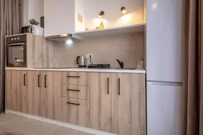 a kitchen with wooden cabinets and a refrigerator at Increíble Loft junto a la ciudad de las ciencias in Valencia