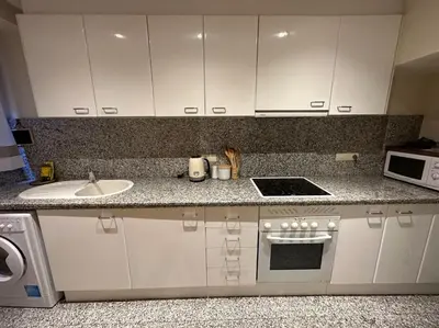 a kitchen with white cabinets and a sink and a stove at Apartamento Almas Centro in Valencia