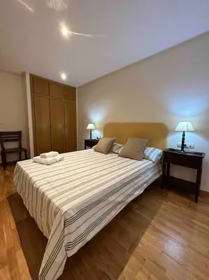 a bedroom with a large bed with two tables and two lamps at Apartamento Almas Centro in Valencia