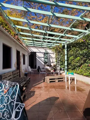 a patio with wooden benches and a blue roof at Trocito de Paraíso en la Sierra Espadán in Eslida