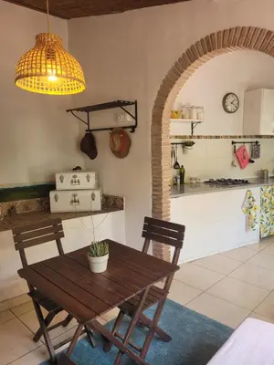 a dining room with a table and a kitchen at Trocito de Paraíso en la Sierra Espadán in Eslida