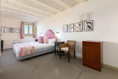 a bedroom with a bed and a desk and a chair at Maison Muralleta B&B in Riba-Roja De Turia
