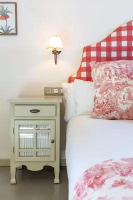 a bedroom with a bed and a night stand next to a bed at Maison Muralleta B&B in Riba-Roja De Turia