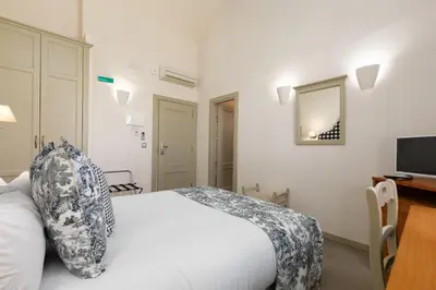 a bedroom with a white bed and a television at Maison Muralleta B&B in Riba-Roja De Turia
