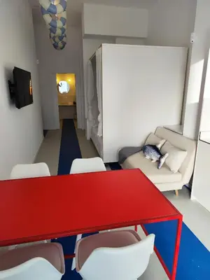 a living room with a red table and chairs at CariSan1 - 6 min to beach, modern, bright in Valencia