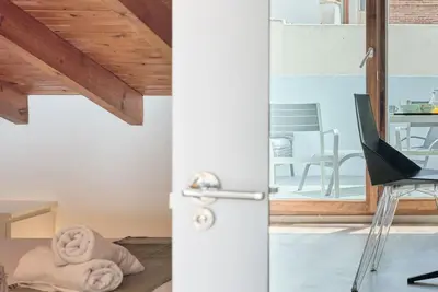 a room with a door and a living room with a chair at Sunny Cozy Penthouse with a Terrace at Plaza del Carmen in Valencia
