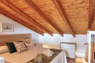 a bedroom with a bed in a room with wooden ceilings at Sunny Cozy Penthouse with a Terrace at Plaza del Carmen in Valencia