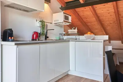 a kitchen with white cabinets and a counter top at Sunny Cozy Penthouse with a Terrace at Plaza del Carmen in Valencia
