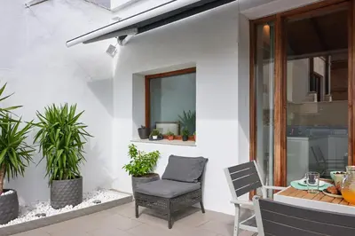 a patio with a chair and a table with plants at Sunny Cozy Penthouse with a Terrace at Plaza del Carmen in Valencia
