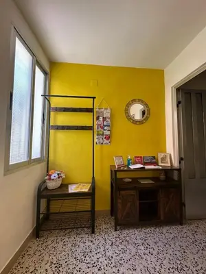 a room with a yellow wall with a desk and a mirror at La Casa de Matilde in Caudiel