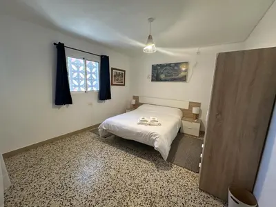 a bedroom with a white bed and a window at La Casa de Matilde in Caudiel