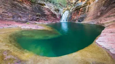 a pool of water in a canyon with a waterfall at La Casa de Matilde in Caudiel