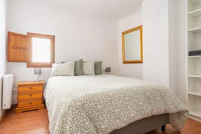 a white bedroom with a bed and a mirror at Casa la Baronia in Chulilla