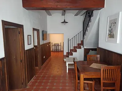 a hallway with a table and chairs and stairs at Casa la Baronia in Chulilla