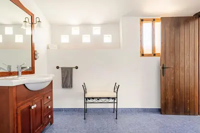 a bathroom with a sink and a chair in it at Casa la Baronia in Chulilla