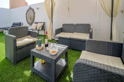 a living room with wicker chairs and a couch at Ático Balinés con vistas al mar in Canet de Berenguer