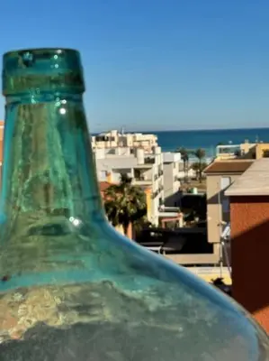 a green glass bottle sitting on top of a building at Ático Balinés con vistas al mar in Canet de Berenguer