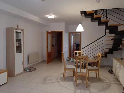 a dining room with a table and chairs and a staircase at Casa Lliri con piscina en Massalfassar VALENCIA in Masalfasar