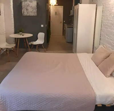 a white bed in a room with a table and chairs at Bonito Alojamiento F in Valencia