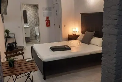 a bedroom with a large bed with a wooden headboard at Bonito Alojamiento F in Valencia
