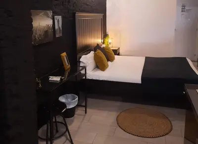 a bedroom with a bed and a table with a stool at Bonito Alojamiento F in Valencia